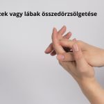 Szürke háttér előtt kezét összedörzsölő nő.