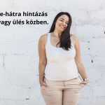 Barna, hosszú hajú, telt alkatú fiatal nő csukott szemmel mosolyogva, fehér trikóban és bézs nadrágban, zsebre tett kézzel áll fehér fal előtt.