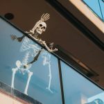 Emberméretű csontváz halloween dekoráció üvegerkélyről integet