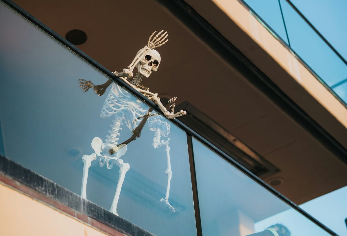 Emberméretű csontváz halloween dekoráció üvegerkélyről integet