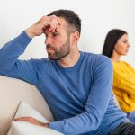 Szorongó férfi ül a kanapén, háta mögött egy nővel