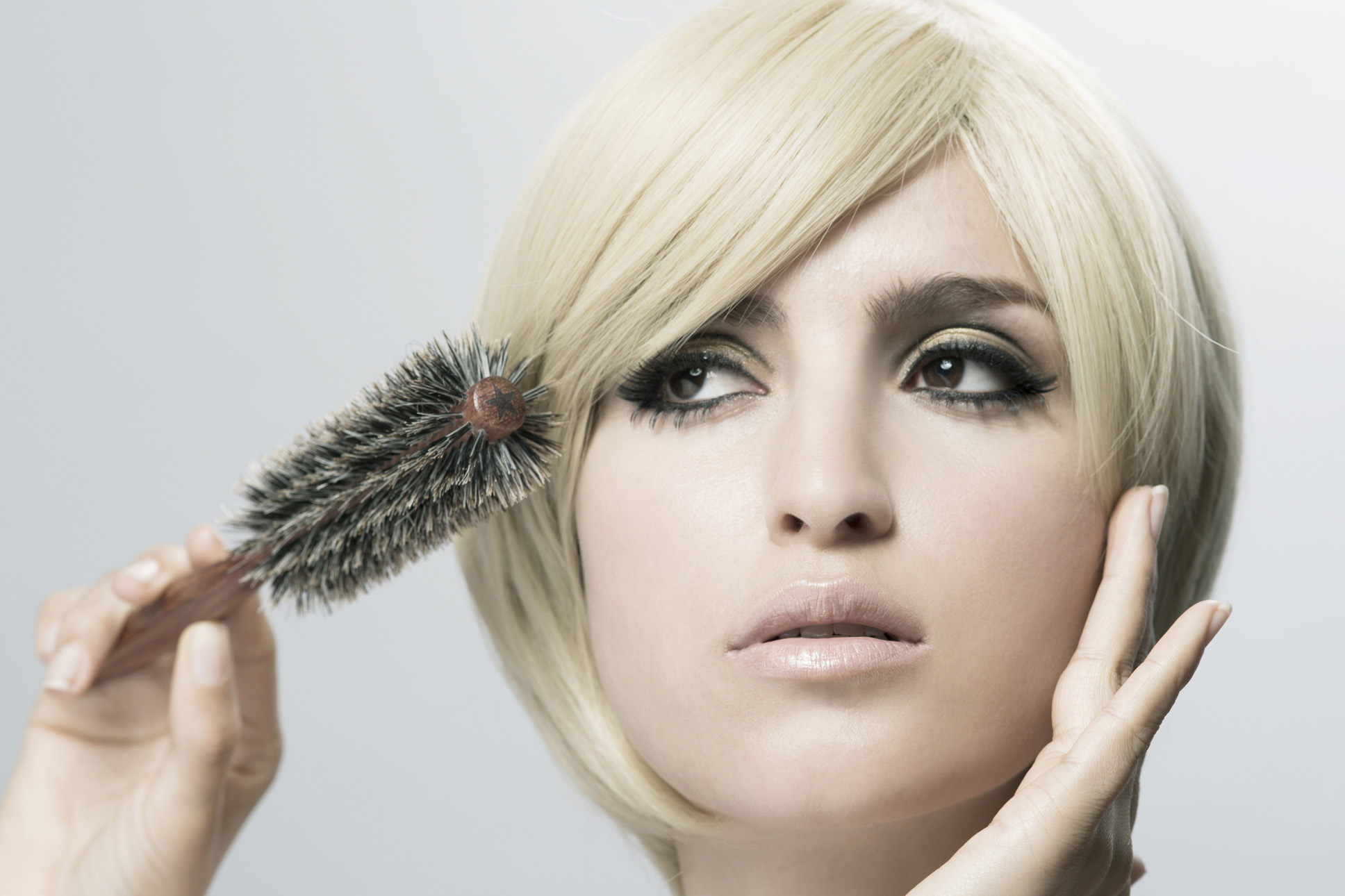 Szőke nő a haját fésüli