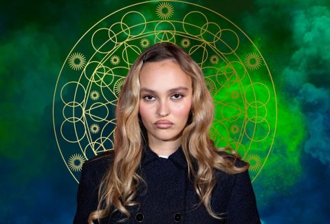Lily Rose Depp erős szájkontúrral, zöld égbolt a háttérben és asztrológiai kör arany színben