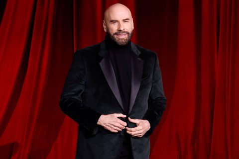 John Travolta mosolyog fekete bársonyzakóban a 2024-es Oscar-gálán