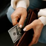 Női kéz pénzt vesz ki pénztárcából