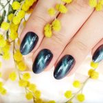 Zöld színű macskaszem manikűr sárga virág dekorációval