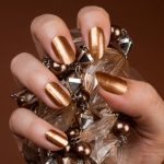 Bronz macskaszem manikűrrel kristályt fog női kéz