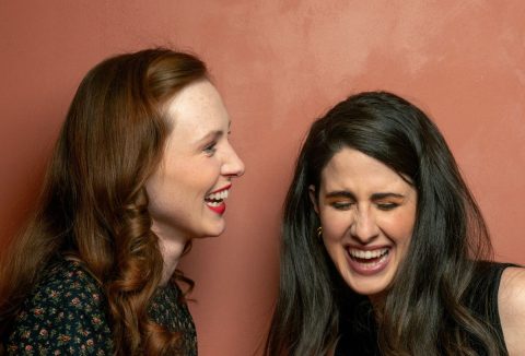 Egy vörös és egy barna hajú szép, fiatal nő nevet