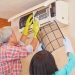 Egy férfi és egy nő tisztítja a légkondicionáló HEPA-szűrőjét