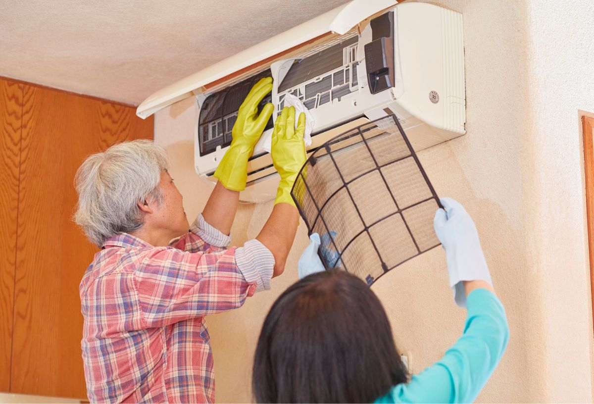 Egy férfi és egy nő tisztítja a légkondicionáló HEPA-szűrőjét