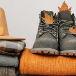 Őszi ruhák, kalap és bakancs összehajtogatva, egymásra pakolva