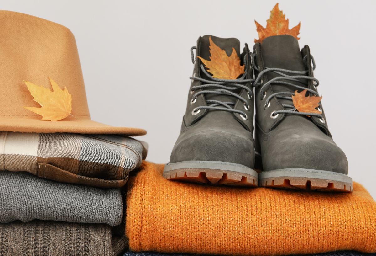 Őszi ruhák, kalap és bakancs összehajtogatva, egymásra pakolva