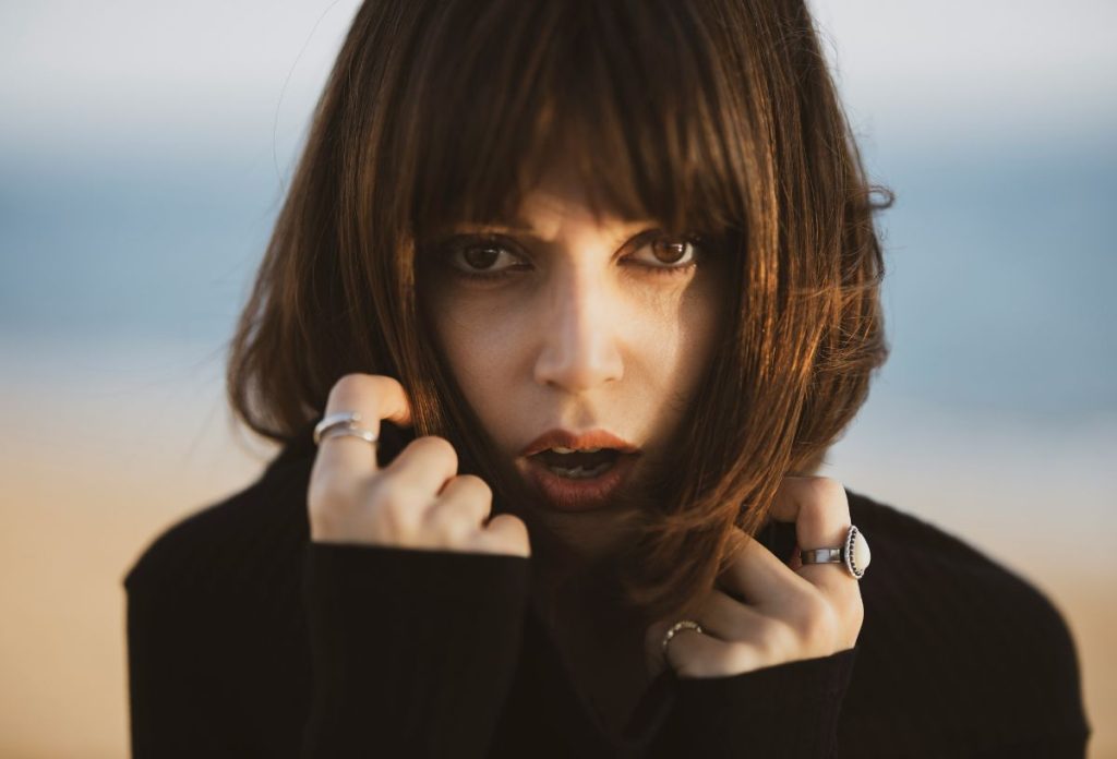 Vonzó, barna hajú és barna szemű fiatal nő fekete garbóban