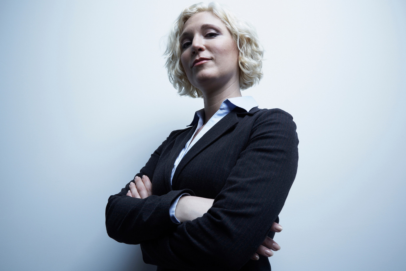 Szőke üzletasszony, aki magabiztosan néz és mosolyog