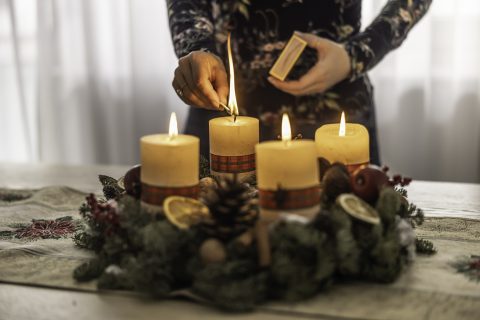 Női kéz adventi gyertát gyújt