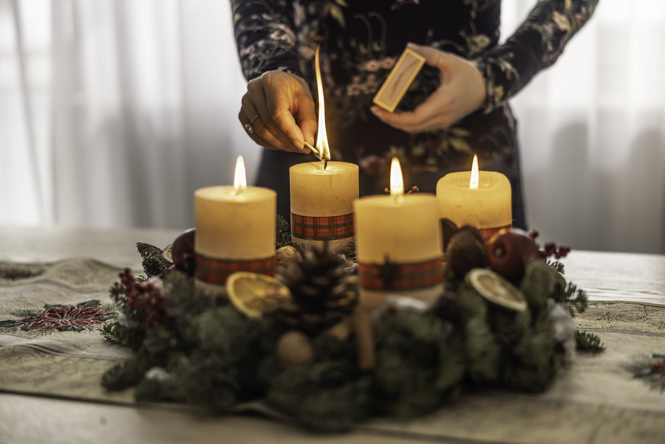 Női kéz adventi gyertát gyújt