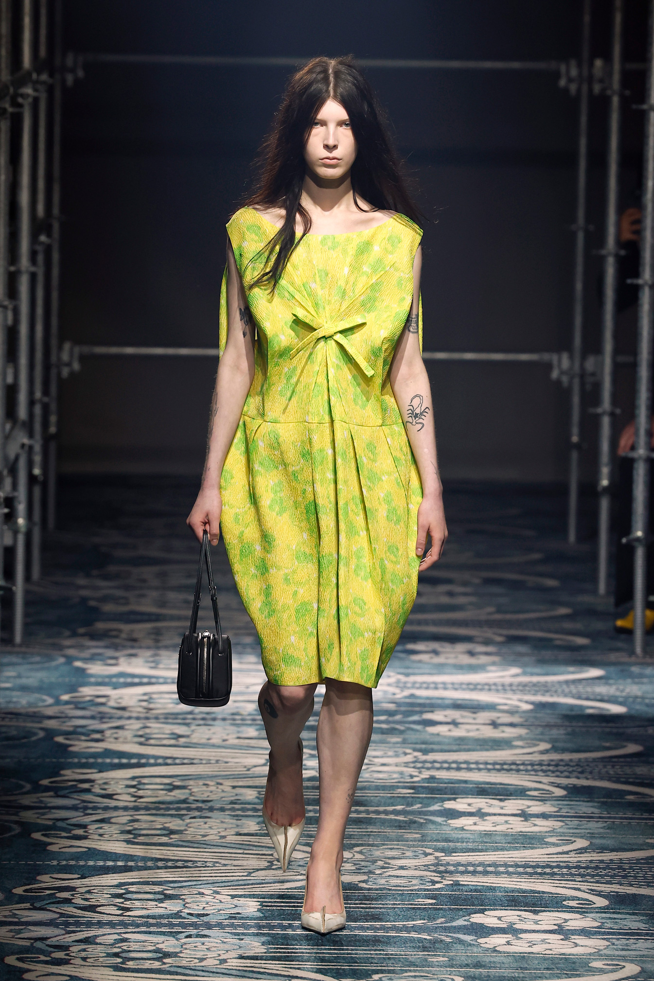 Egy modell sétál a kifutón sárgászöld miniruhában a Prada divatbemutatóján a Milánói Divathéten 2025. február 27-én, Milánóban, Olaszországban