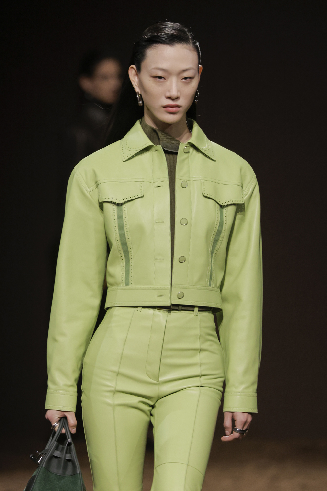 Egy modell sétál a kifutón sárgászöld bőrkabátban és bőrnadrágban a Hermès Ready to Wear 2025-2026 őszi/téli divatbemutatóján a Párizsi Divathét részeként, 2025. március 8-án, Párizsban, Franciaországban