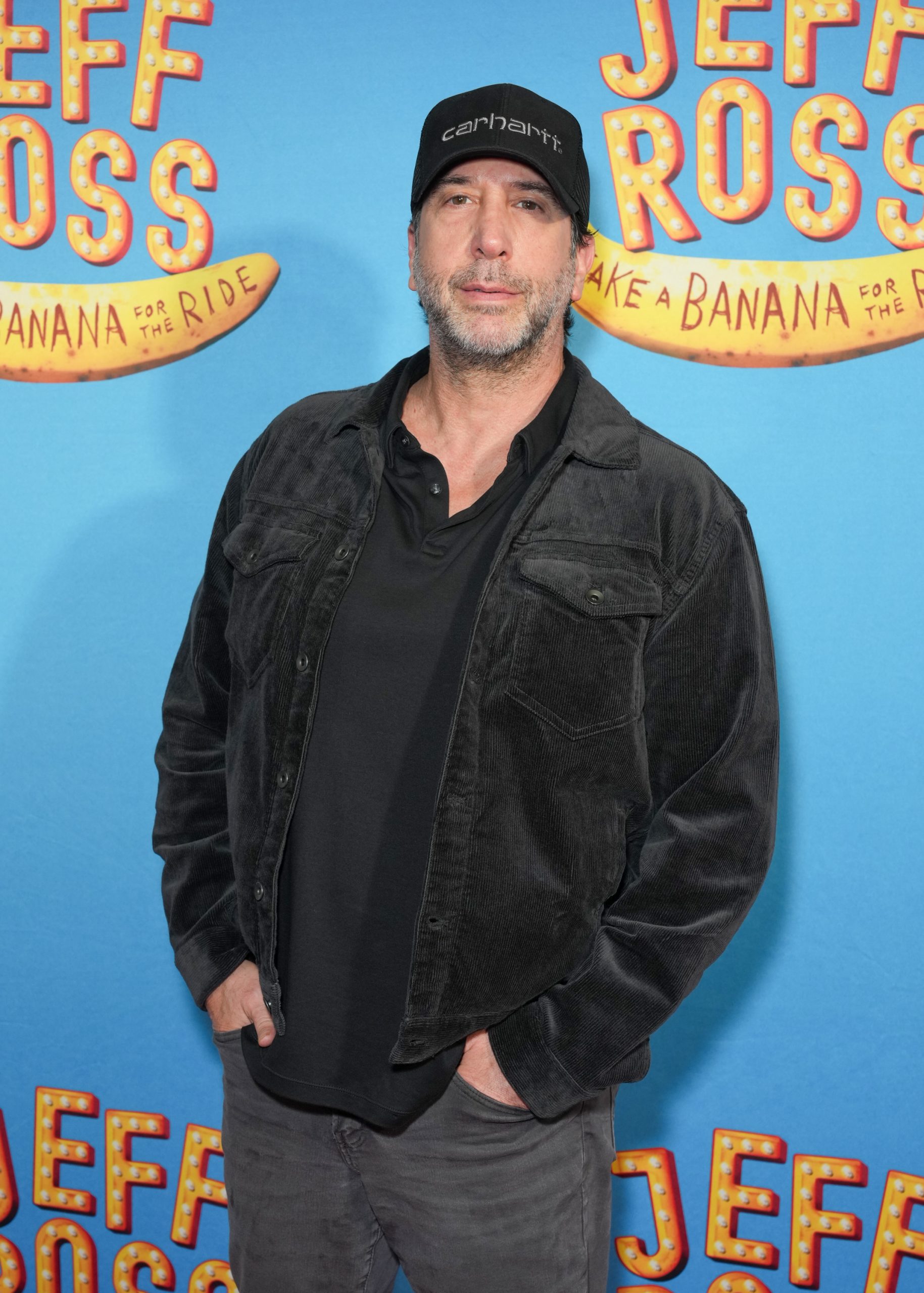 David Schwimmer baseball sapkában és fekete ruhában a Jeff Ross: Take A Banana For The Ride című Broadway-előadás nyitóestjén, amelyet 2025. augusztus 18-án tartottak a New York-i Nederlander Színházban