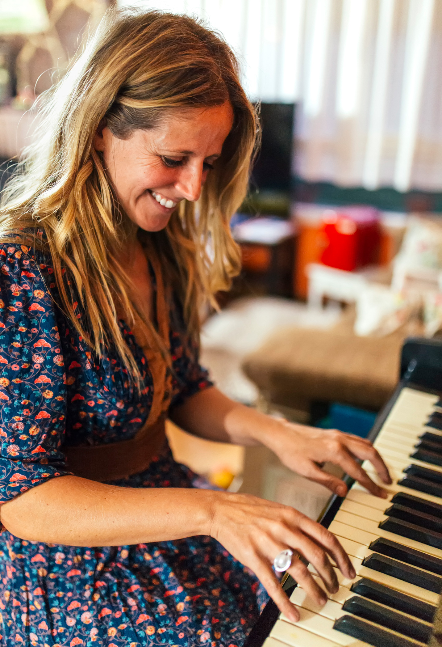 Egy nő mosolyogva zongorázik