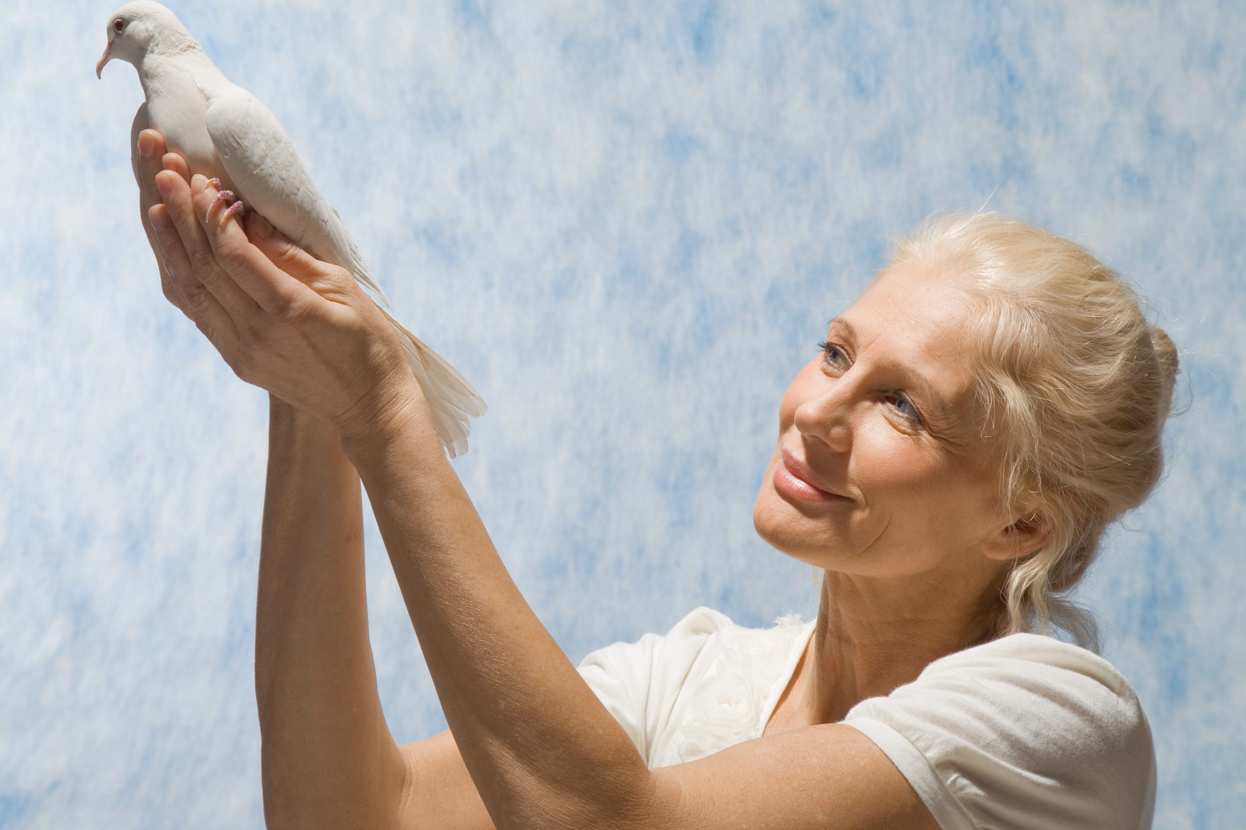Nő tart galambot a kezében