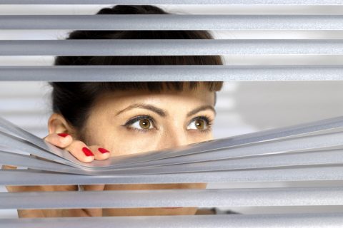 Egy nő az irodában a reluxán keresztül figyel másokat