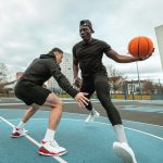 Két férfi kosárlabdázik, versengenek egymással