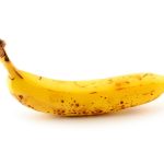 Egy darab érett, barna foltos banán fehér háttéren