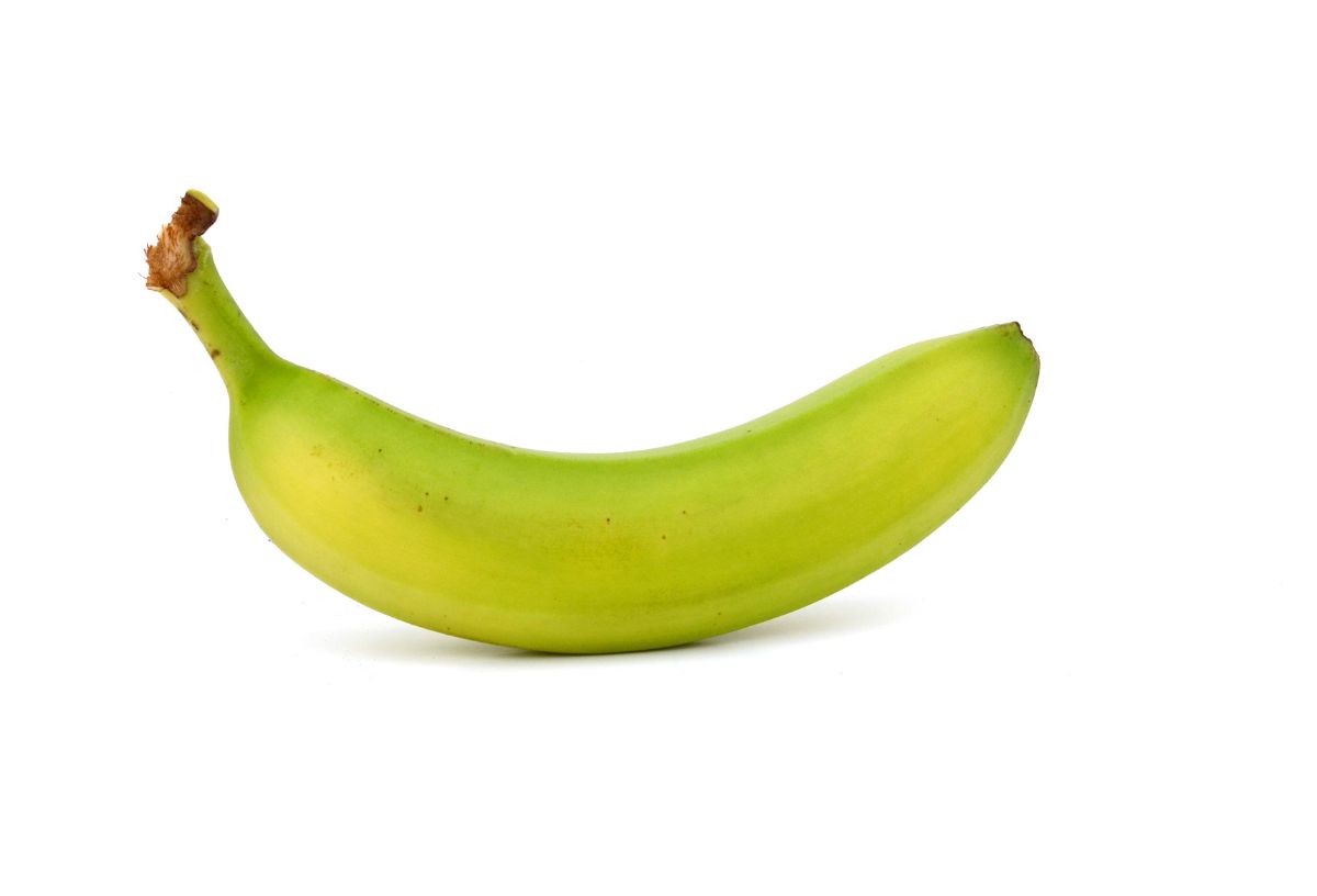 Egy darab zöld, éretlen banán fehér háttéren
