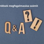 Szürke háttéren Q és A, kérdőjel és felkiáltójel fából gravírozva