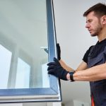 Szakember fekete kesztyűben vizsgálja az ablaküveget