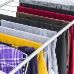 Közeli képen színes és szürke, fekete ruhák ruhaszárítóra terítve