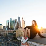 Egy lány ül egy magas épületen a város felett