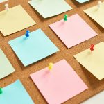 Színes post it címkék parafa táblára tűzve