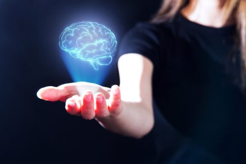 Egy női kéz fölött gy emberi agy hologramja látható.