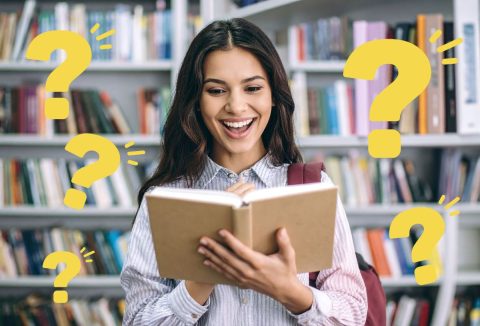 Fiatal, szép nő boldogan könyvet lapoz, háttérben elmosódott könyvespolc, sárga kérdőjelek