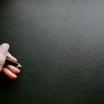 Kéz ceruzát fog sötét háttér előtt