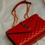 Piros luxus táska pasztell háttér előtt