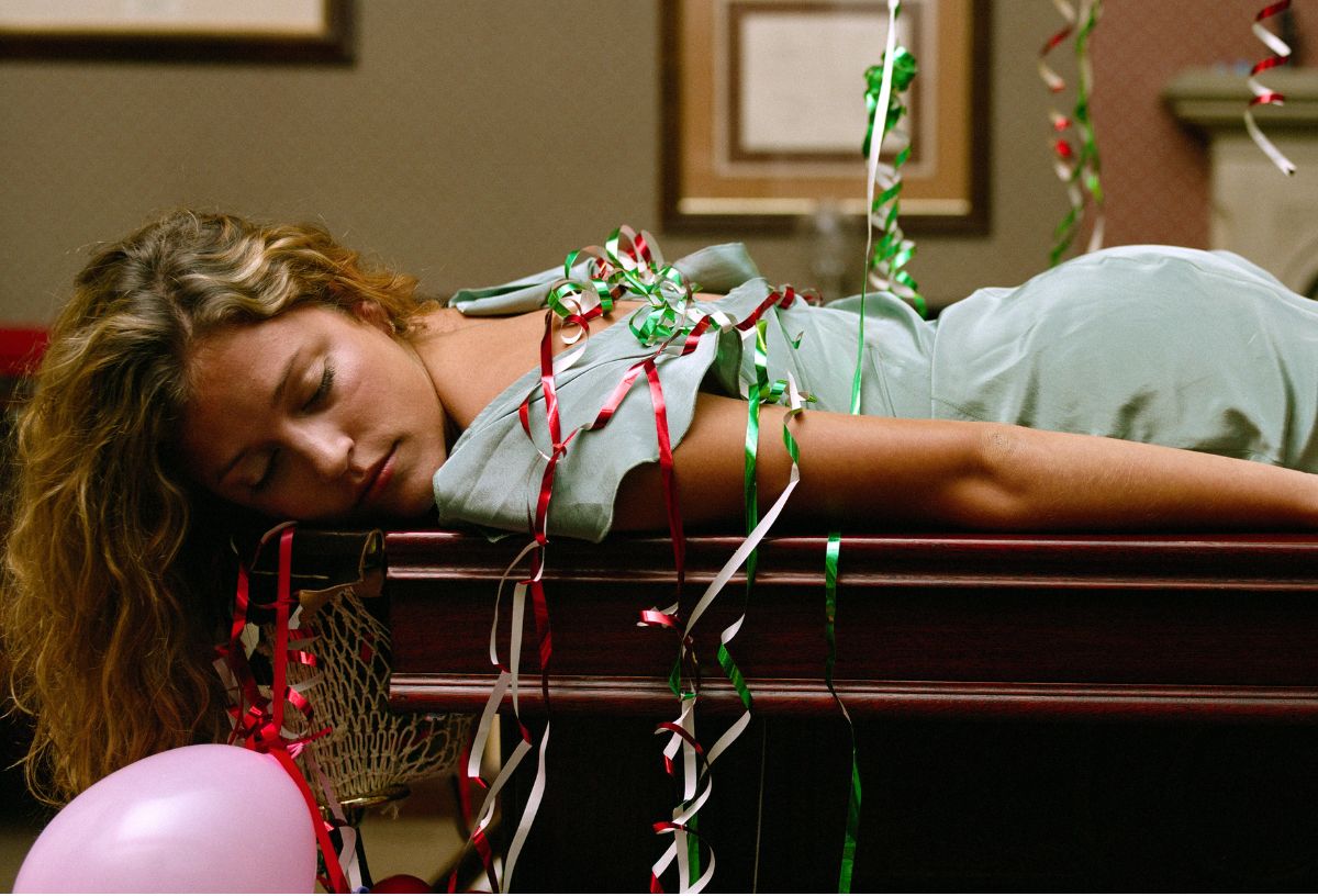 Céges karácsonyi buli után nő konfettivel a hátán az irodai asztalon alszik