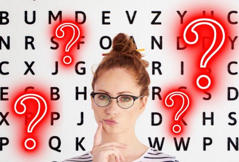 fiatal, vöröshajú nő kontzba tűzött hajjal, szemövegben, gondolkodó arckifejezéssel, háttérben betűk, piros kérdőjelek