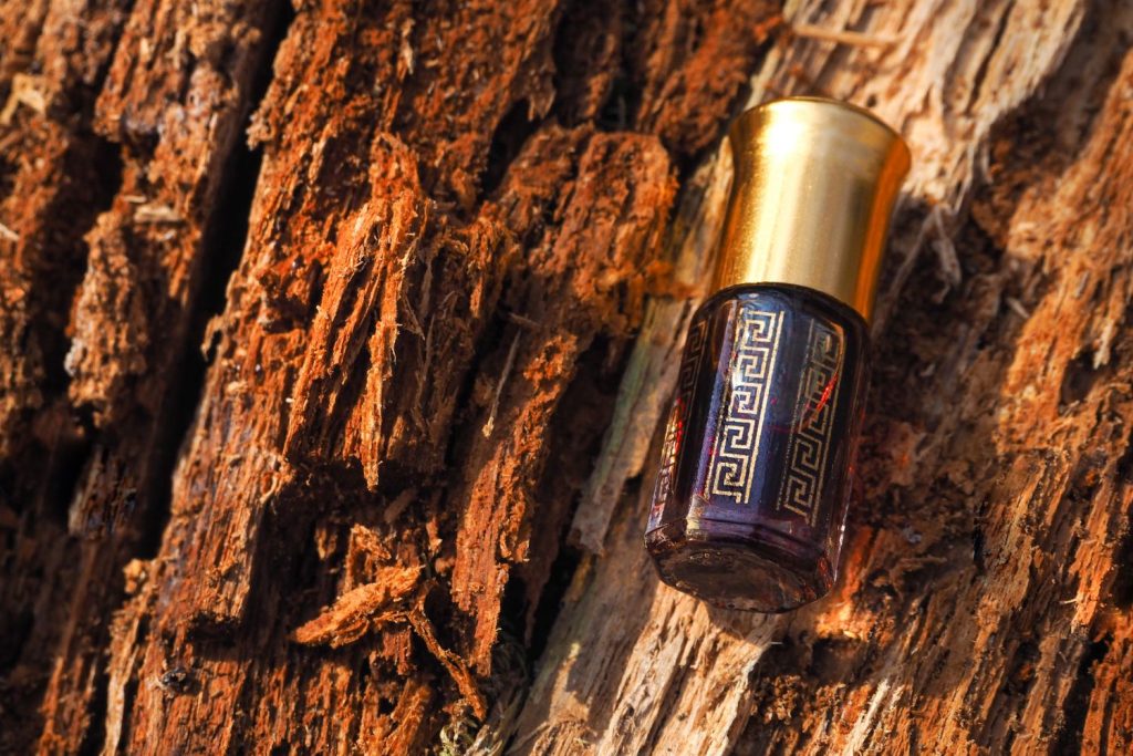 egy üveg oud parfüm fával a háttérben