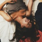 Hosszú barna hajú nő fekszik az ágyon