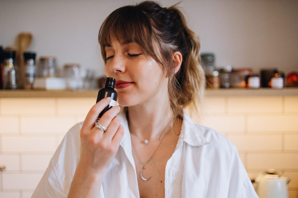 gyönyörű nő illatos üvegcsét szagol