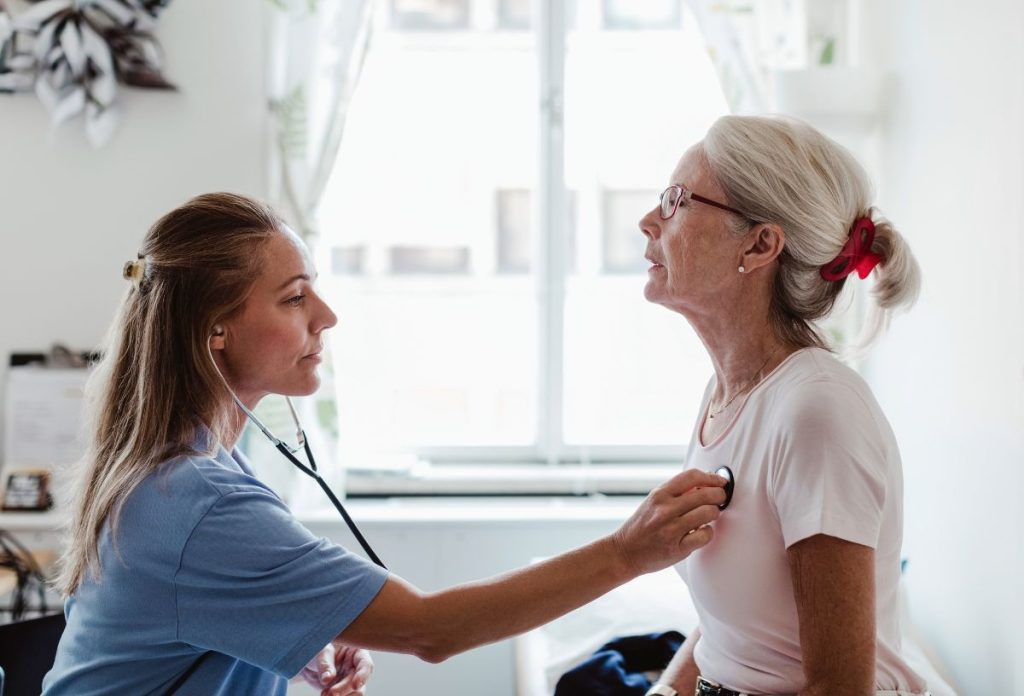 Nő orvos vizsgálja középkorú női beteg szívét sztetoszkóppal