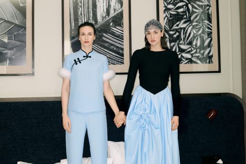 Törőcsik Franciska és húga Hanna kék, illetve fekete színú ruhát viselve állnak egy ágyon egy hálószobában