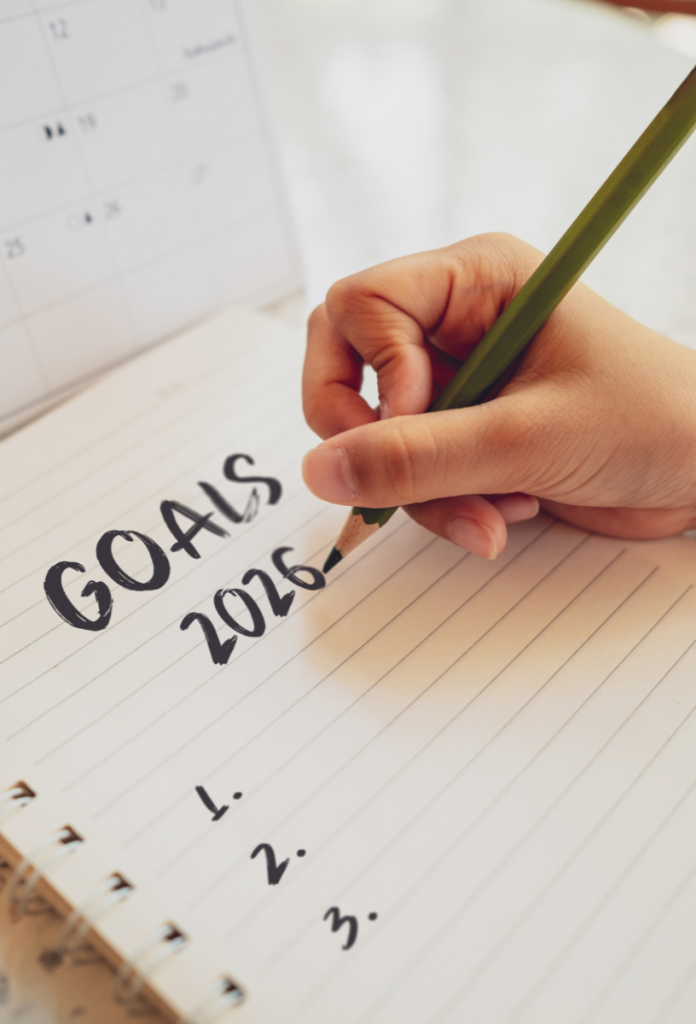 Nő ceruzával a 2026-os céljait sorolja fel vonalas füzetbe