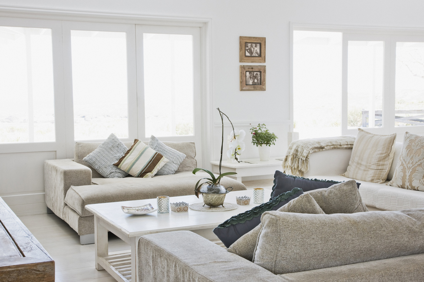 Egy fehér, modern nappali kanapékkal és dohányzóasztallal