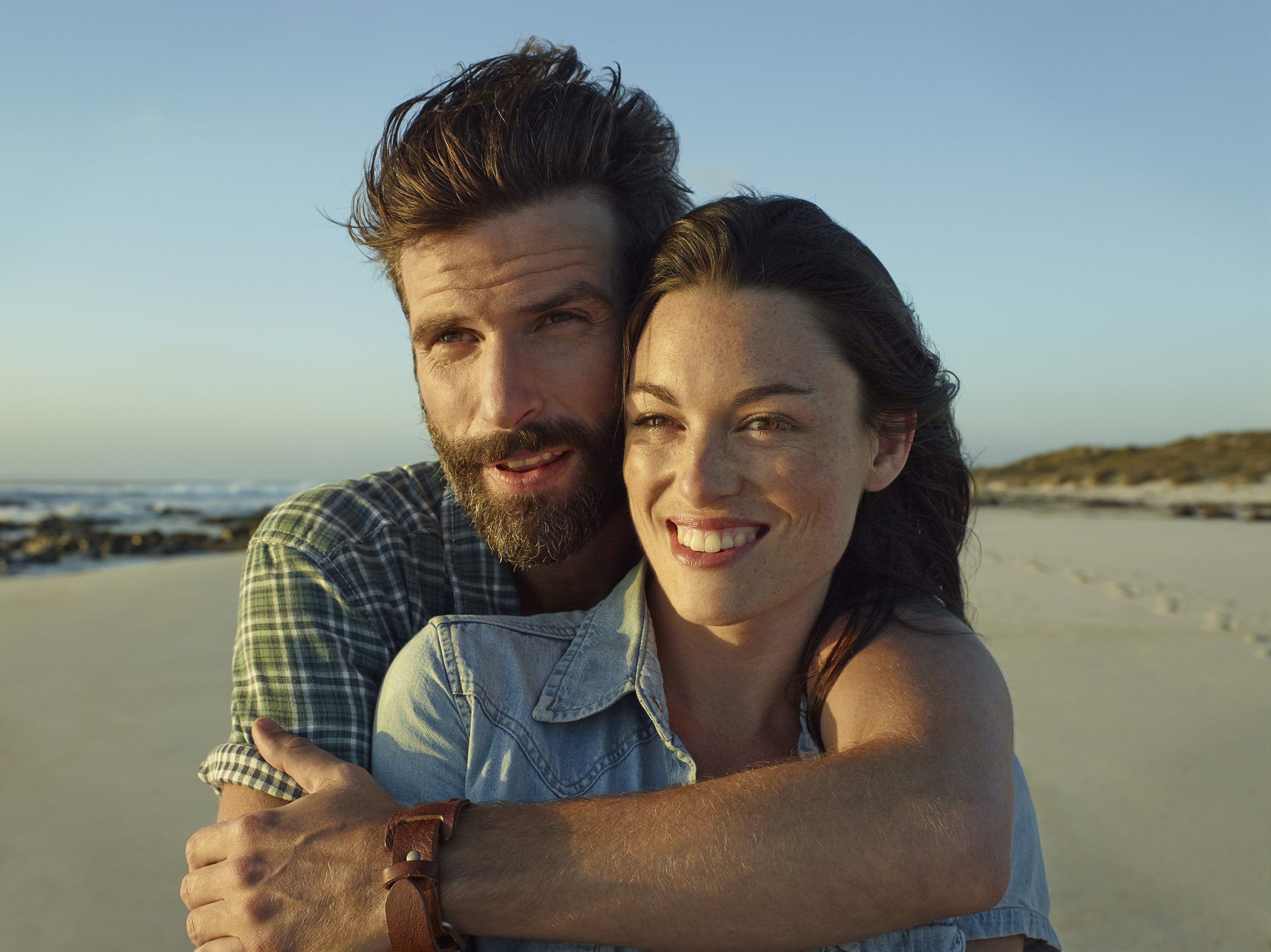 Fiatal pár a tengerparton öleli egymást