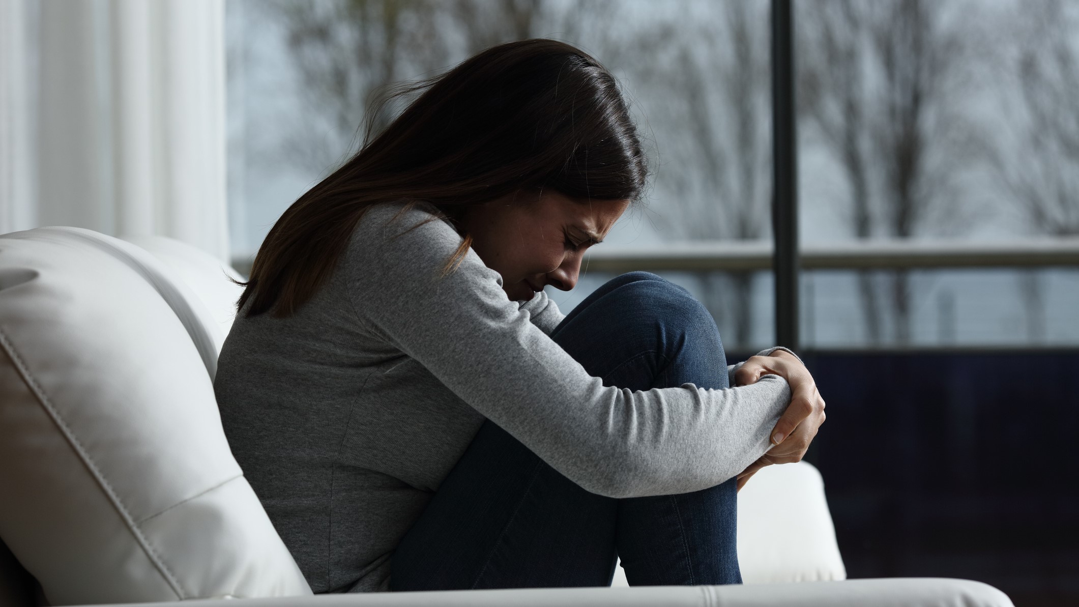 Egy nő összekuporodva sír