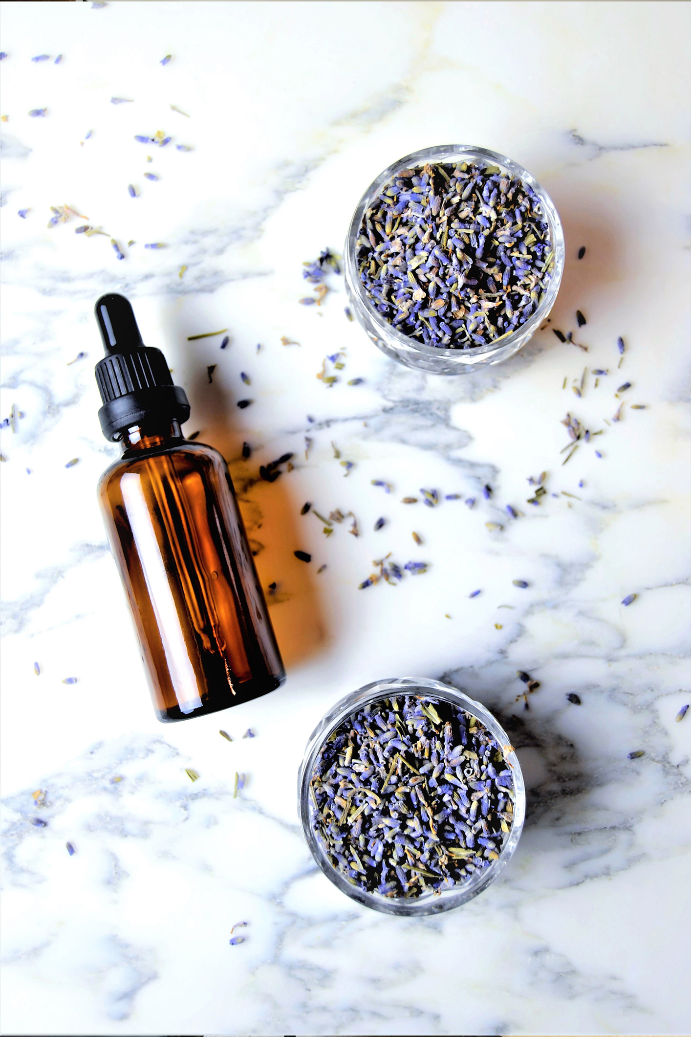 illatositok-keszitese-hazilag | Marie Claire Illóolajos üveg az asztalon, körülötte levendula két tálkában